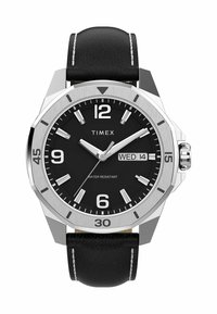 Montre Timex avec un bracelet en cuir noir, boîtier rond en argent, cadran noir, index horaires blancs et affichage de la date. Fonctionnalité étanche notée.