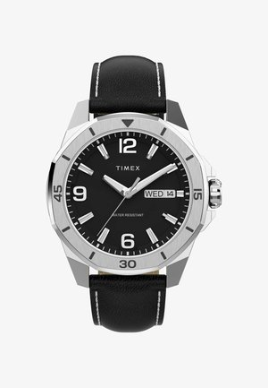 Timex ura z črnim usnjenim trakom, okroglo srebrno ohišje, črn številčnica, beli kazalci za ure in prikaz datuma. Opozarja na vodoodporne lastnosti.
