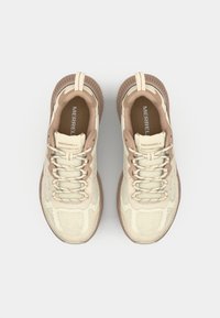 Baskets en mesh beige avec des accents marron, présentant un design à lacets, une languette rembourrée et une semelle en caoutchouc texturée. Logo "MERRELL" visible sur la languette.