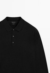 Black long-sleeve polo shirt made from 100% merino wool. Features a classic collar and three button placket. Smooth texture.