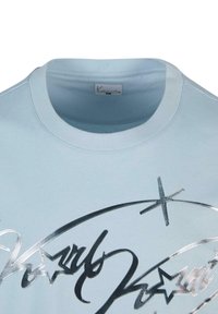 Hele helesinine puuvillane T-särk, millel on hõbedane metallisest trükiga tekst ja tähed, ümar kaelus, lühikesed varrukad ja lõdva lõikega.