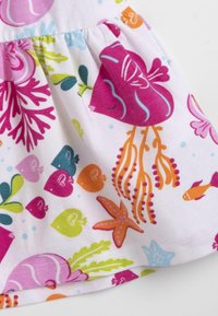 Koftklänning i bomull med en vit bakgrund och färgglada marin-temade motiv, inklusive maneter, fiskar och koraller i rosa, orange och grönt.