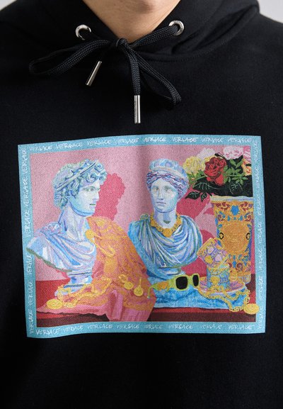 Black hoodie featuring a colorful graphic of classical busts with floral accents, framed by a blue border, and repeated "Versace" text.
