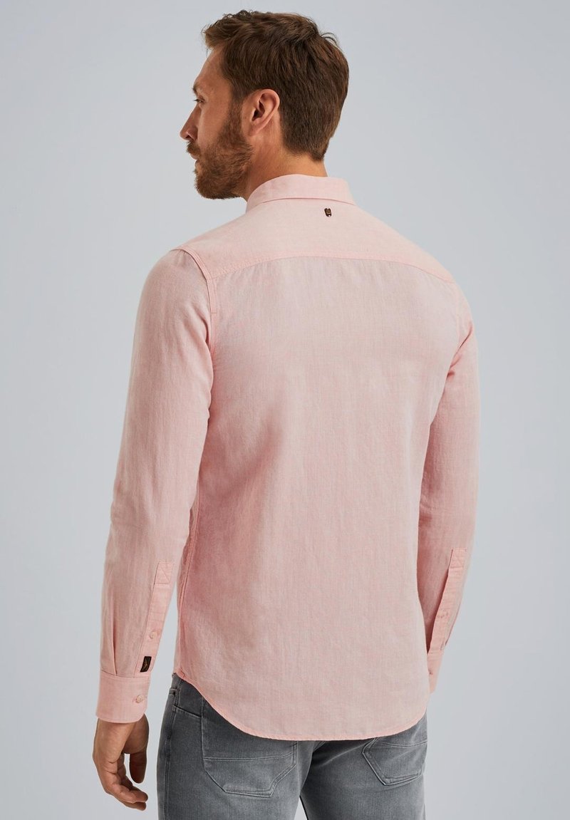 Světle růžová košile s dlouhým rukávem, button-down límcem, manžetami na jeden knoflík a zakřiveným lemem. Materiál vypadá texturovaně a lehce.
