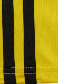Gele stof met twee verticale zwarte strepen. Het materiaal lijkt glad met een gestructureerde afwerking. Zichtbare stitching in contrasterend geel.