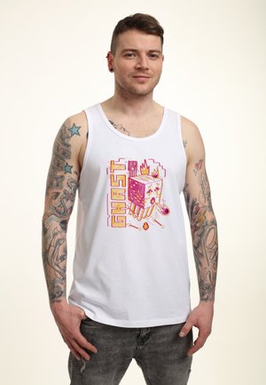 Hvid bomulds tanktop med en farverig grafik af en figur med flammer, omgivet af pixeliserede designs og ordet "GHAST."