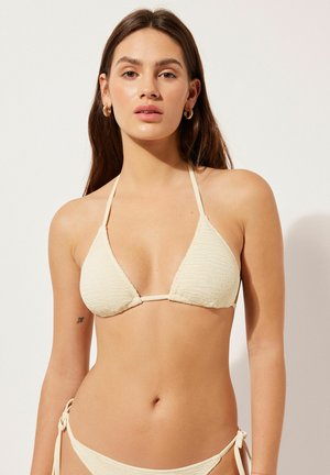 Bikini de couleur crème avec des bonnets triangulaires texturés, des liens ajustables au niveau des hanches et des bretelles fines. Design simple, adapté pour un maillot de bain.
