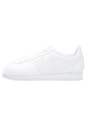 Baskets basses blanches avec fermeture à lacets, dessus en cuir lisse, logo Nike cousu et semelle en caoutchouc texturée.