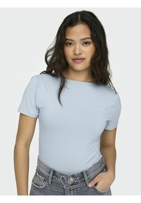 Lyseblå kortermet t-skjorte, figursydd design, ribbet tekstur, rund hals. Sammen med høytlivde grå denimshorts med slitte detaljer.