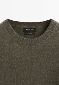 Olijfgroene ronde hals trui gemaakt van 100% kasjmier met geribbelde kraag en een Massimo Dutti merklabel aan de binnenkant van de hals.