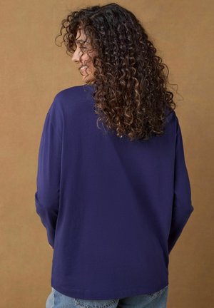 Navy top met lange mouwen van zachte stof, ontspannen pasvorm, ronde halslijn, met een gladde textuur en dropped shoulders. Casual, veelzijdige stijl.