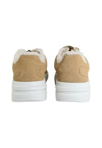 Sneakers in suede beige con suole bianche, dotati di fodera in fleece sul colletto, chiusura con zip e accenti di cuciture curve sui lati.