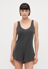 Mono gris sin mangas con escote en V y pantalones cortos pequeños, hecho de una tela texturizada. Presenta una costura central y detalles de costura simples.