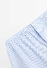 Blue and white striped fabric with an elastic waistband and two buttons at the top, featuring a smooth texture and casual design.
