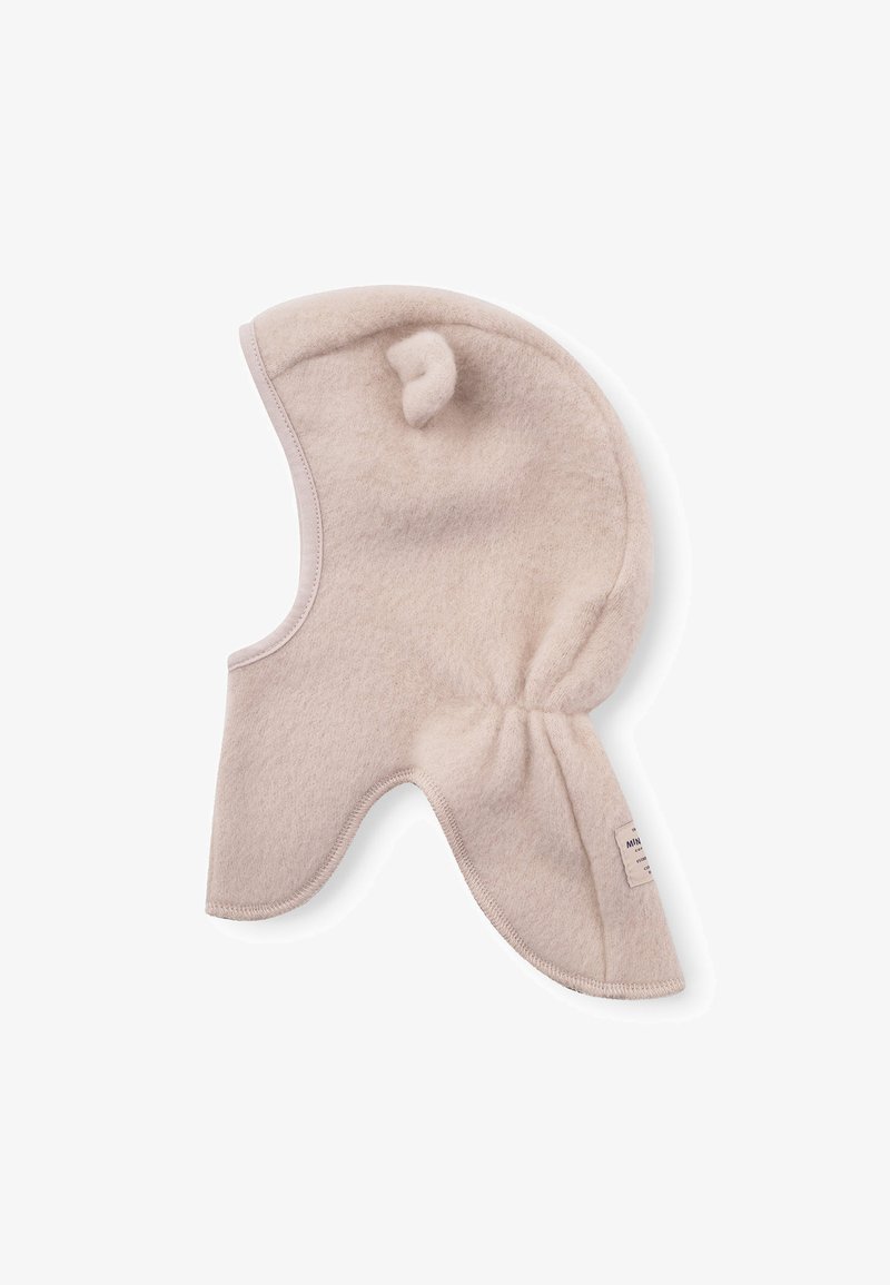 Béžová fleecová kukla s kulatým tvarem, bočními klapkami a malým třásněním. Šitá náplast na boku. Měkká textura.