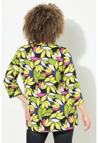 Kleurige tuniek met een levendig bladerenpatroon in groen, wit en roze op een zwarte achtergrond, met driekwart mouwen en een losse pasvorm.