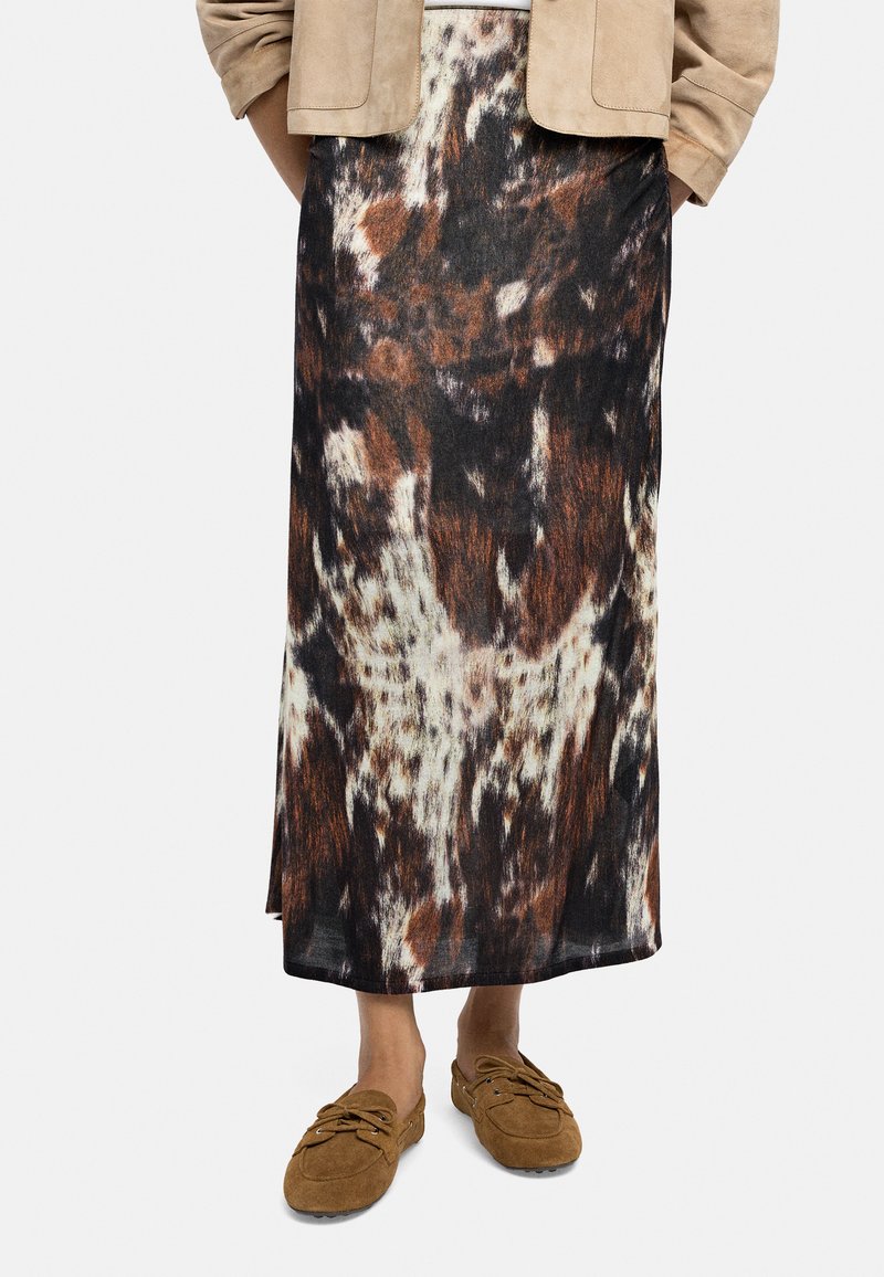 Długa, wzorzysta spódnica w odcieniach brązu, czerni i kremu. Wykonana z lekkiego materiału, ma prosty krój i rozcięcia po bokach.