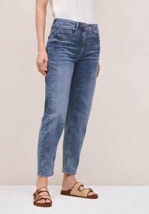 Lichtblauwe, high-waisted jeans met twee voorklepzakken en knoopsluiting. Draag ze met tan geklede slidesandalen met dubbele gespen.