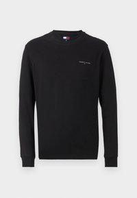 T-shirt noir à manches longues en coton, avec un col rond et un petit logo blanc sur la poitrine gauche, doté de poignets côtelés.