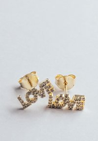 Goldene Ohrringe in Form des Wortes "LIEBE", verziert mit klaren Strasssteinen. Das Design verfügt über eine polierte Oberfläche und Schmetterlingsverschluss.