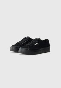 Sneaker casual nere in suede con lacci piatti, punta rotonda e suola in gomma spessa. Presenta un branding minimale e un design classico.