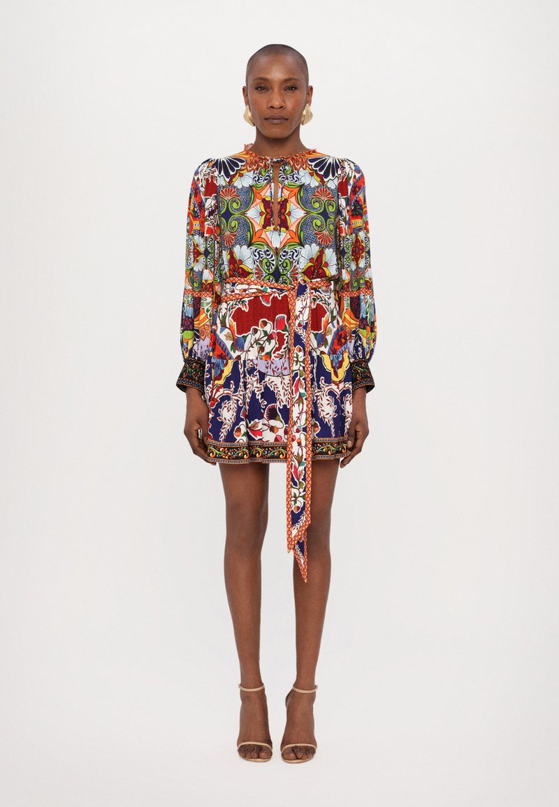 Multi-patterned dress in vibrant colors, featuring long sleeves, a tie waist, and a mix of floral and geometric designs. Smooth fabric.