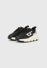 Ασπρόμαυρα chunky αθλητικά παπούτσια με κορδόνια, μπεζ λεπτομέρειες και χοντρή υφή σόλας, τοποθετημένα δίπλα-δίπλα σε απλό φόντο.