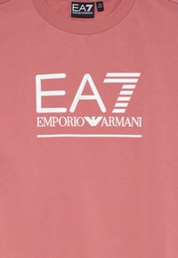 Ružový odev s bielym logom EA7 Emporio Armani a etiketou s veľkosťou 14A a 160 CM na okrúhlom výstrihu.