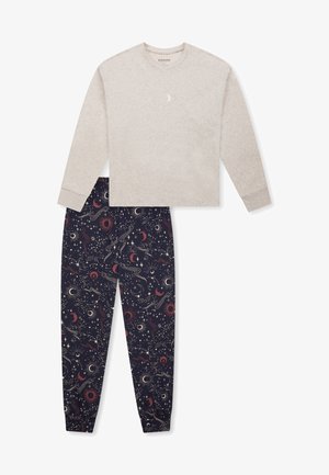 Beige Langarmoberteil mit Halbmonddetail, kombiniert mit dunkelblauen Hosen, die ein himmlisches Muster aus Sternen, Planeten und Wirbeln aufweisen.