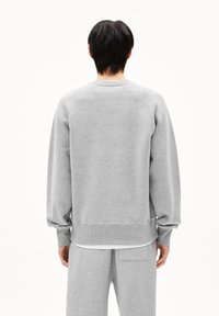 Grijze sweatshirt met raglanmouwen, geribbelde boorden en zoom. Zacht van textuur. Heeft een relaxte pasvorm en wordt gedragen met bijpassende broek.