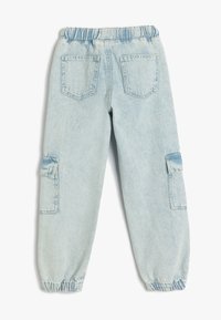 Pantaloni in denim blu chiaro con vita elastica, orli svasati, due tasche posteriori e tasche laterali cargo. Texture liscia, vestibilità comoda.