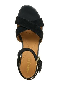 Sandalo in suede nero con cinghie incrociate e chiusura a fibbia. Presenta una soletta imbottita color tan e una punta arrotondata.