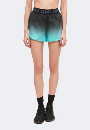 Kvinde iført sorte til turkis ombre træningsshorts, sorte sokker og sorte sneakers, vist fra taljen til fødderne mod en hvid baggrund.