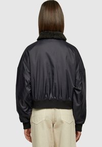 Jachetă bomber neagră cu guler din faux fur și talie elastică, având un exterior neted și lucios și un design cu umeri căzuți.