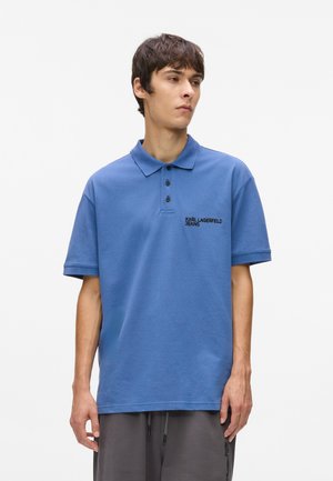 Niebieska koszulka polo wykonana z bawełny, z klasycznym kołnierzykiem, dwiema guzikami oraz haftowanym logo "Karl Lagerfeld Jeans" na piersi.