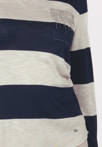 Maglione a righe con strisce orizzontali blu navy e beige chiaro, tessuto leggero, una piccola tasca con accenti di strass.
