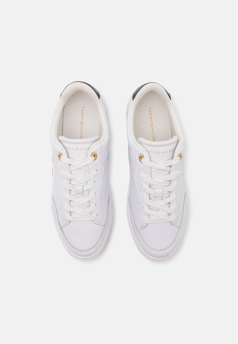 Baskets en cuir blanc avec bout rond, lacets à l'avant, œillets dorés et semelle intérieure marquée. Présente des coutures discrètes et une texture lisse.