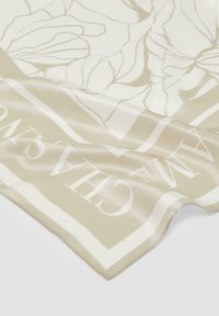 Écharpe en soie beige avec des contours floraux et une bordure blanche contrastante. La texture est lisse avec une finition polie.