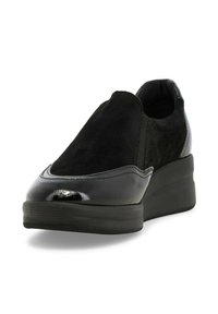Sneaker nera slip-on con un mix di suede opaco e pelle lucida, caratterizzata da una punta tonda e una suola a zeppa spessa.