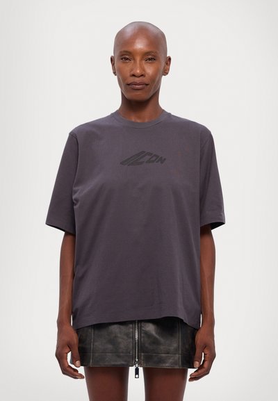 T-shirt en coton gris à manches courtes et col rond, avec un logo noir imprimé sur la poitrine. Coupe droite et légèrement ample.