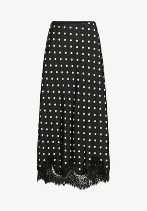 Jupe à pois en tissu noir avec des pois blancs, dotée d'un ourlet en dentelle festonnée. La jupe a une texture lisse et une forme évasée.