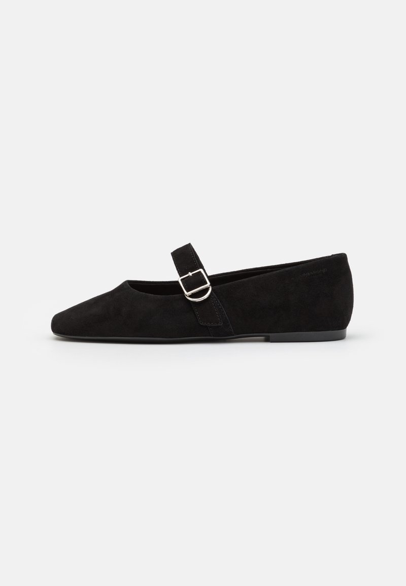 Chaussure plate Mary Jane en daim noir avec bout pointu et bride à boucle argentée sur fond blanc.