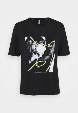 Camiseta de algodón negra con un diseño gráfico de un rostro con acentos de líneas amarillas y la frase "BAILEMOS EN LA OSCURIDAD" debajo.