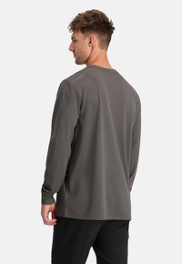 Sportieve lange mouwen shirt in donkergrijs, met een gestructureerd meshpatroon, slim fit en een ronde hals. Logo-opdruk op de schouder.