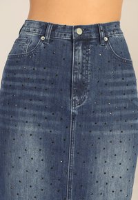 Jeansrok met een aansluitende pasvorm, donkerblauwe kleur, versierd met zwarte rhinestones, voorzien van een klassieke knoopsluiting en voorzakken.
