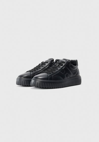 Pair of black leather low-top sneakers with thick grooved soles and black laces, positioned side by side on a white background.