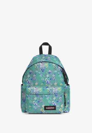 Mochila verde con un diseño floral, de forma redondeada, con tirantes ajustables y un bolsillo frontal, que cuenta con un parche de logo y detalles en negro en los cierres.
