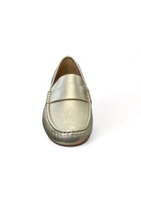 Metalen gouden loafers met een gladde textuur, ronde neus en een gestikte accentband over de bovenkant. Platte zool en instapontwerp.