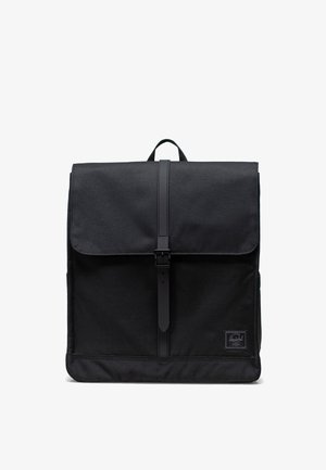Schwarzer Rucksack mit einem Stoffaußenmaterial, umklappbarem Deckel und einem Schnallenverschluss. Minimalistisches Design mit einem Logo-Patch am Boden.
