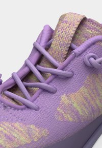 Κοντινό πλάνο μοβ πλεκτού αθλητικού παπουτσιού με κορδόνια στο ίδιο χρώμα και υφασμάτινη θηλιά στο πίσω μέρος με κίτρινο και ροζ σχέδιο.